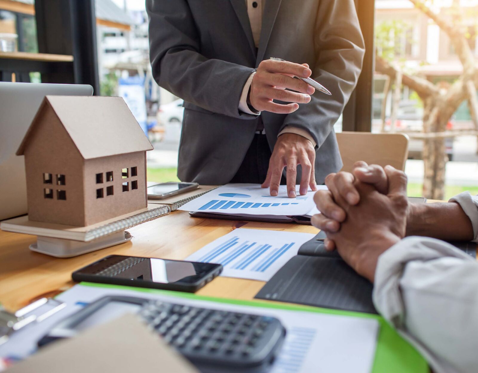 Advisor reviewing a plan with a business owner beside a model house